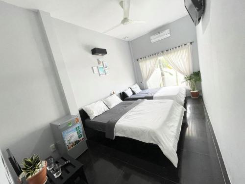 a bedroom with two beds and a tv in it at Evergreen Tree Homestay in Phan Thiet