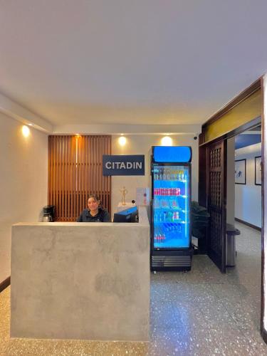 a man sitting at a counter in an office at Hotel Citadin Z10 in Guatemala