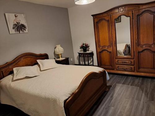 - une chambre avec un lit et une grande armoire en bois dans l'établissement Maison d'une chambre avec jardin clos a Thoisy la Berchere, à Thoisy-la-Berchère