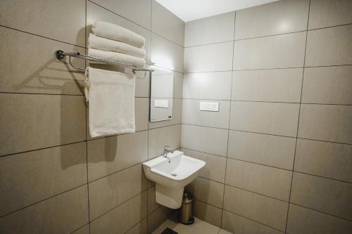 AthirappillyAthirappilly Rainland Resort的带水槽、马桶和毛巾的浴室