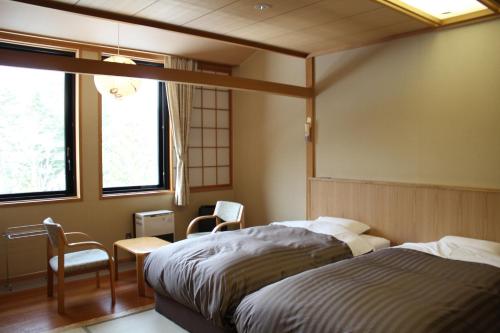 a bedroom with two beds and a table and chairs at Moritsubetsu in Tsubetsu