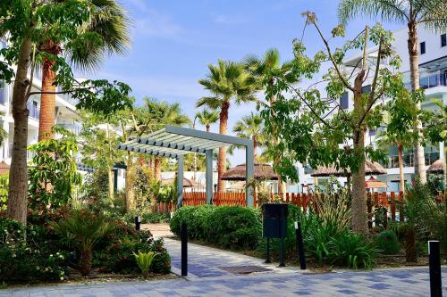 a park with palm trees and a blue canopy at Aguacate Beach Apartamentos Playa Granada in Motril