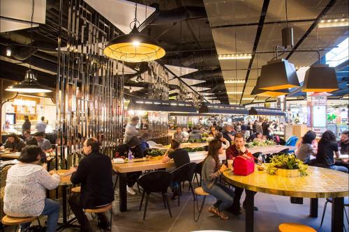 um grupo de pessoas sentadas em mesas em um restaurante em Designer Styled Studio in Central Trendy Glebe em Sidney