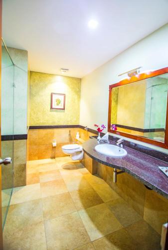 a bathroom with two sinks and a mirror at Club Paraiso in Raipur