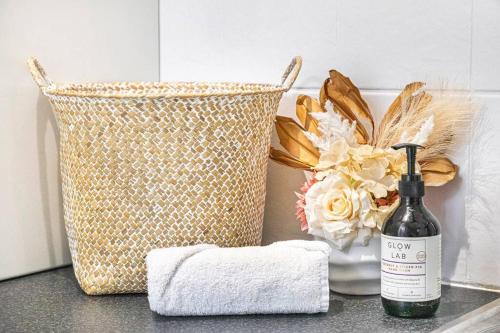 a bottle of wine and a basket of flowers on a counter at Marina View - Waterfront Stunner with Plunge Pool in Darwin