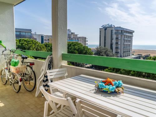 a bench on a balcony with a bike and a view at Apartment in Bibione near tennis court in Bibione