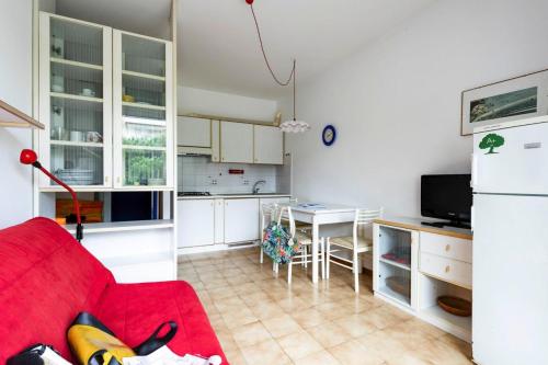 a living room with a red couch and a kitchen at Apartment in Bibione near tennis court in Bibione