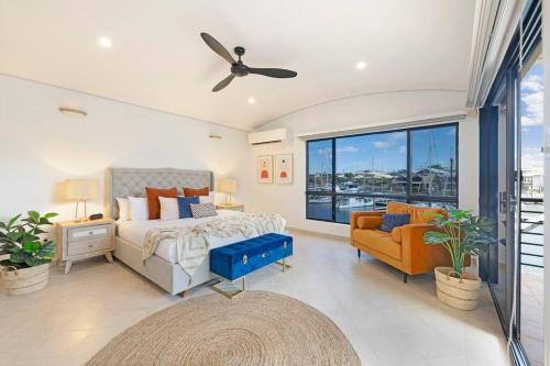 1 dormitorio con cama, sofá y ventana en Marina View - Waterfront Stunner with Plunge Pool, en Darwin