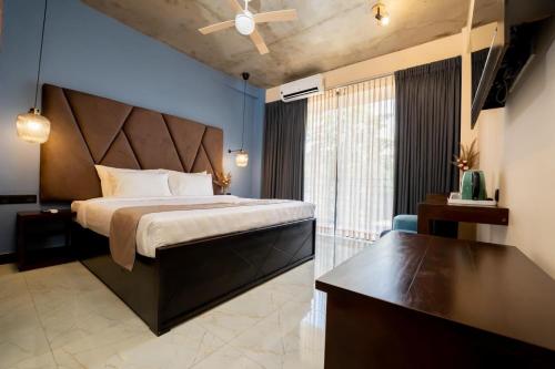 a bedroom with a large bed with a ceiling fan at Limeshine - Airport Transit Hotels & Residences in Katunayake