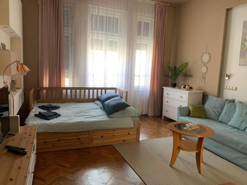 a living room with a bed and a couch at Hangulat apartman in Miskolc