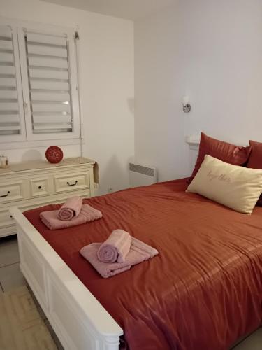 une chambre avec un lit avec deux serviettes dessus dans l'établissement Bas de villa avec jardin piscine clim proche plages calanques, à Marseille