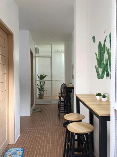 a room with stools and a bar with plants at Maligaya Maison in General Luna