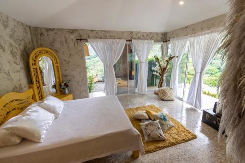 a bedroom with a bed and a large window at BOSQUE EL DESCANSO in Jamundí