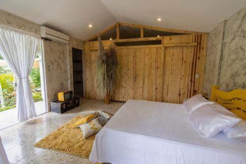 a bedroom with a large white bed and a window at BOSQUE EL DESCANSO in Jamundí