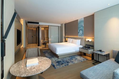 a hotel room with a bed and a couch at Courtyard by Marriott Shenzhen Northwest in Bao'an