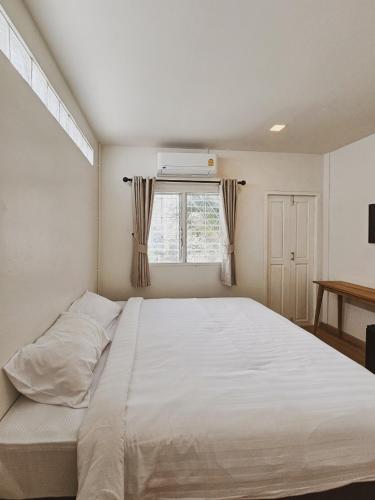 a bedroom with a large white bed and a window at Casa Maya House in Phi Phi Islands