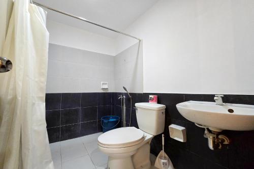 a bathroom with a toilet and a sink at Surfside hostel LU Surftown in San Juan