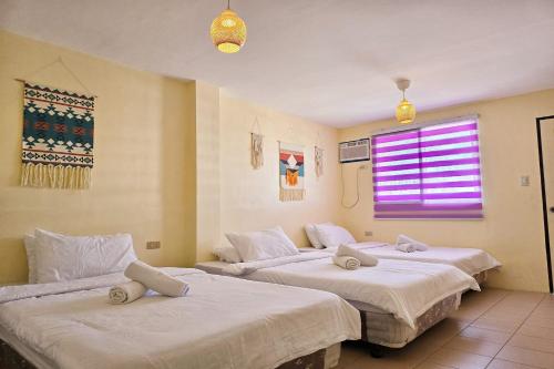 2 camas en una habitación con ventana en Surfside Hostel en San Juan