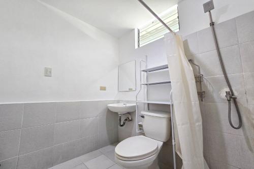 y baño con aseo, lavabo y ducha. en Surfside Hostel, en San Juan