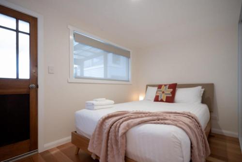 Kings ParkModern Self Contained Unit Views Parking and WiFi的卧室配有一张白色的床,床上有毯子