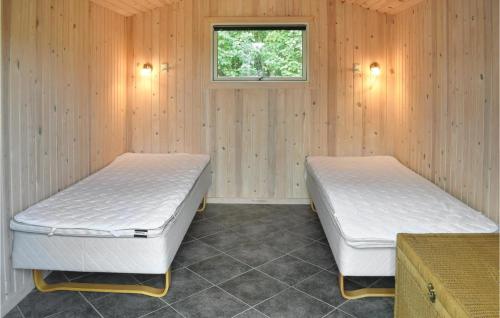 HouにあるNice Home In Tranekr With 4 Bedrooms, Sauna And Wifiのベッド2台 木製の壁の部屋