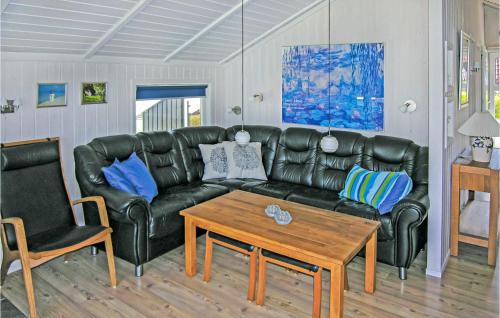 SpodsbjergにあるHoliday Home Drejet Rudkøbing Iiiのリビングルーム(黒い革張りのソファ、テーブル付)