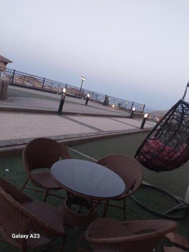 a table and chairs on a patio with a view of the ocean at بورتو السخنه هيفين هيلز شاليه عائلات Heaven Hills Porto El sokhna in Ain Sokhna