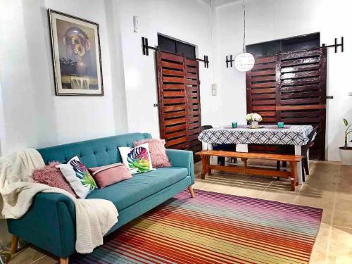 a living room with a blue couch and a table at CamiStays Homestay in Camiguin, Best for Groups or Family in Mambajao