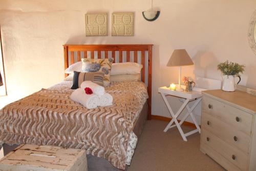 a bedroom with a bed with two stuffed animals on it at Silo Cottage in Underberg