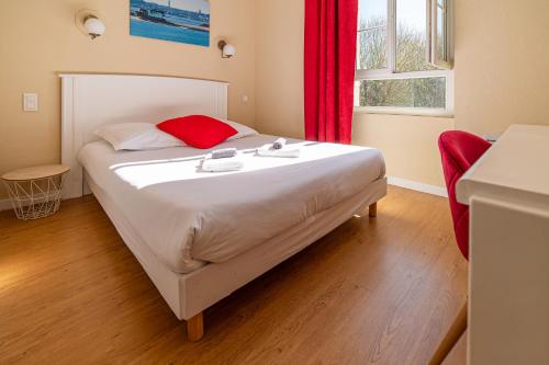 a large bed in a room with a red curtain at Hôtel de la Mairie in Saint-Pol-de-Léon