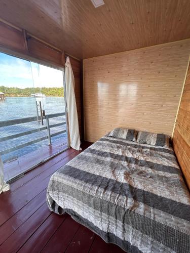 a bedroom with a bed and a large window at Casa flutuante - Manaus Amazonas in Manaus