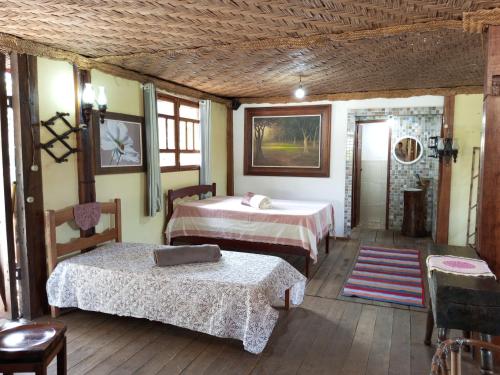 a room with two beds and a table and chairs at Fazenda Mundo Novo in Divisa