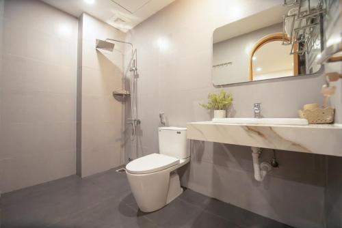 La salle de bains est pourvue de toilettes, d'un lavabo et d'une douche. dans l'établissement Secret Garden FLC Sầm Sơn, à Sầm Sơn