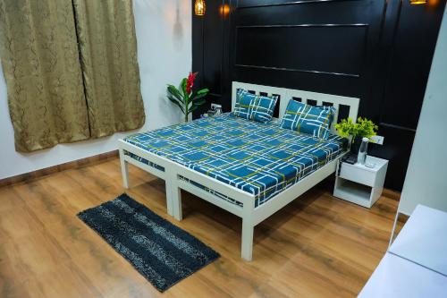 a bed in a room with a blue and white at Agrah Stay - Kasa Lusso Stay in Faridabad