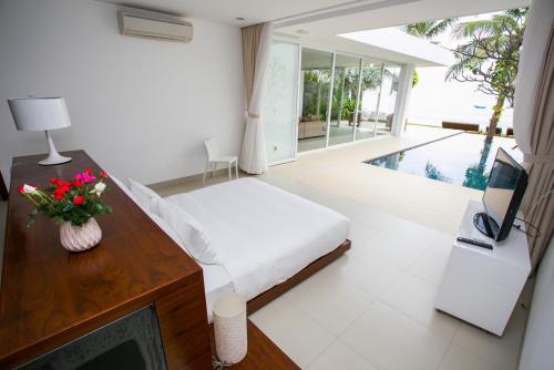 a bedroom with a bed and a desk with a television at Villa - Biệt Thự Nghỉ Dưỡng Phan Thiết in Bình Sum