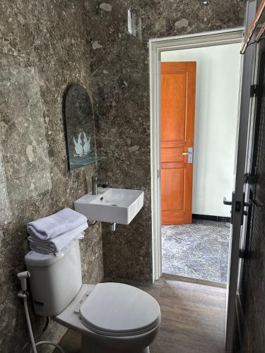 a bathroom with a toilet and a sink at Nofrah House Syariah Mitra RedDoorz in Tjolomadu