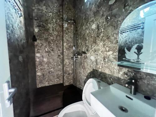 a bathroom with a white toilet and a sink at Nofrah House Syariah Mitra RedDoorz in Tjolomadu