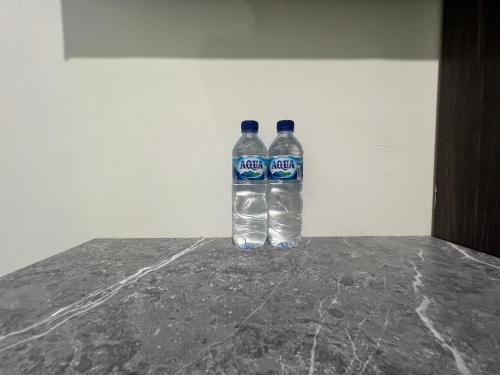 two bottles of water sitting on top of a counter at Nofrah House Syariah Mitra RedDoorz in Tjolomadu