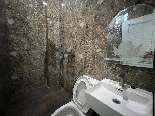 een badkamer met een wastafel, een toilet en een douche bij Nofrah House Syariah Mitra RedDoorz in Tjolomadu