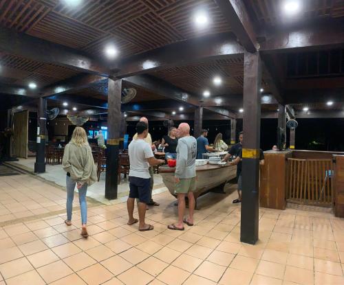 a group of people standing around a buffet in a restaurant at Plengkung Lodge G-Land in Ringinpintu