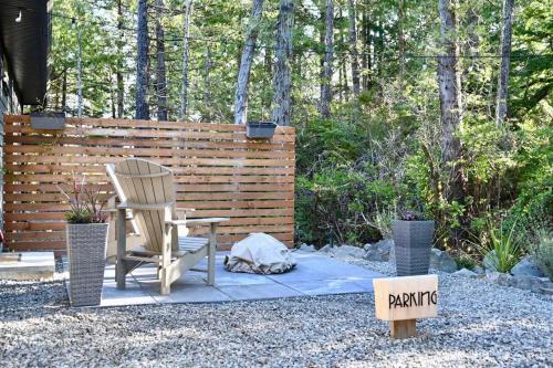 a patio with a chair and a table and a fence at Winter's Hideaway Suite in Ucluelet
