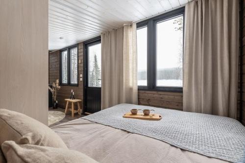 Un dormitorio con una cama y una bandeja. en VADELMA Lapland Riverside Cabin with Sauna Fireplace BBQ Ski Ylläs River Pet WiFi, en Äkäslompolo