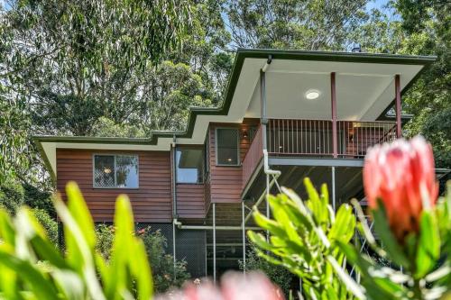 a house with a balcony and flowers in front of it at Yume House - Stylish Country Escape 2 Bedrooms in Ravensbourne