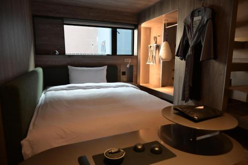 a hotel room with a bed and a table with a table at NOA Hotel & SPA Shenzhen in Shenzhen