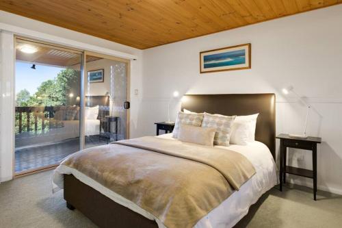 1 dormitorio con 1 cama grande y balcón en Windsong at Ravensbourne Escape 1 Bedroom, en Ravensbourne