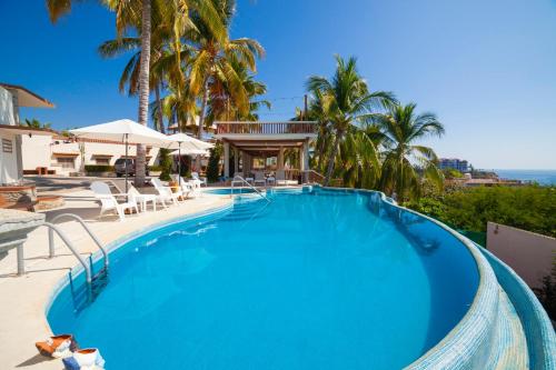 a pool at a resort with palm trees at Hotel Casa Rush in Puerto Ángel