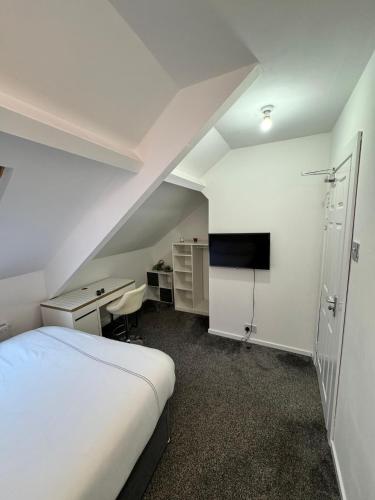 um quarto com uma cama, uma secretária e uma televisão em Luxury Ensuite Rooms @ Kingsley Terrace em Newcastle upon Tyne