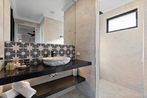 a bathroom with a sink and a mirror at Affinity Luxury Studio with Spa and Amazing Views in Ravensbourne