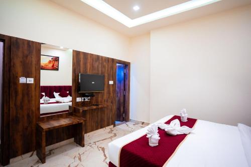 a hotel room with a bed and a tv at HOTEL JSR KEDAR in Varanasi