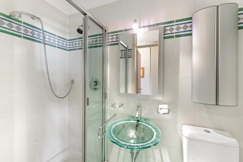a bathroom with a glass sink and a shower at Comfort Holiday In Paradiso - Happy Rentals in Paradiso